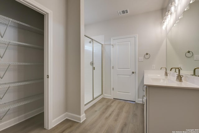 bathroom with vanity, wood-type flooring, and a shower with door