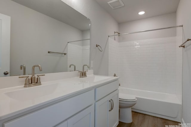 full bathroom featuring vanity, wood-type flooring, shower / washtub combination, and toilet