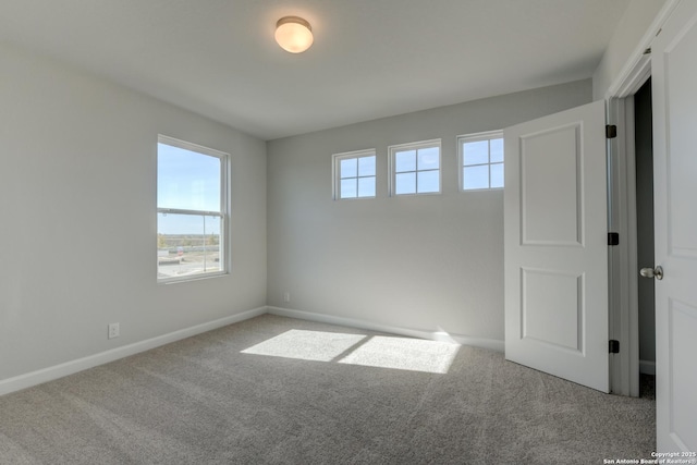 unfurnished room featuring light carpet