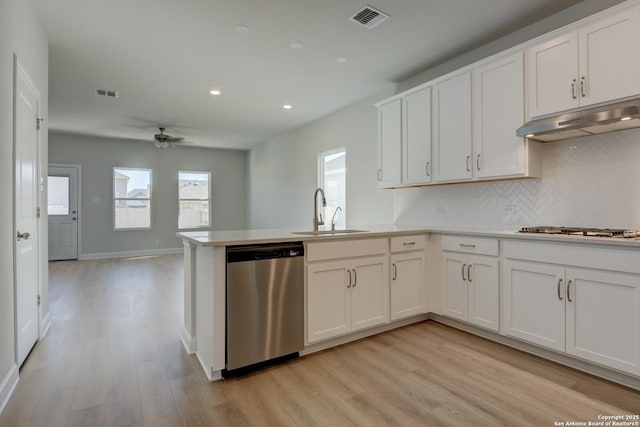 kitchen featuring sink, white cabinetry, kitchen peninsula, stainless steel appliances, and light hardwood / wood-style floors