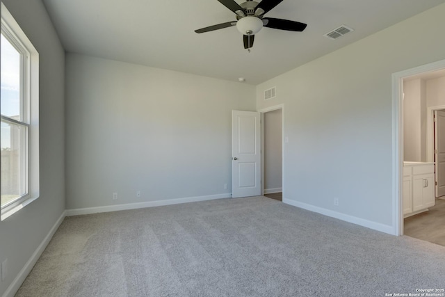 unfurnished room with ceiling fan, light colored carpet, and a healthy amount of sunlight