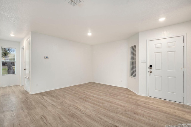 entrance foyer with light hardwood / wood-style floors and a textured ceiling