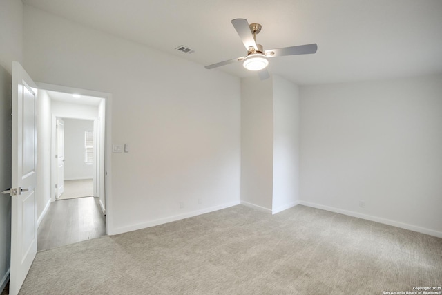 carpeted spare room featuring ceiling fan