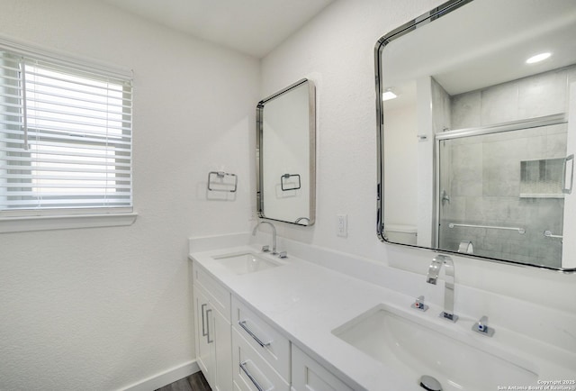 bathroom featuring plenty of natural light, an enclosed shower, and vanity