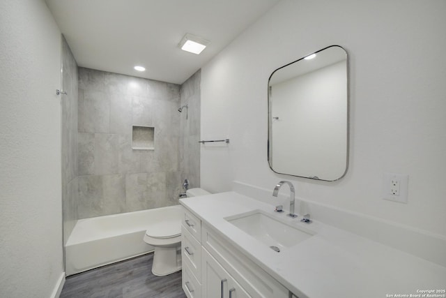 full bathroom with hardwood / wood-style flooring, vanity, toilet, and tiled shower / bath combo