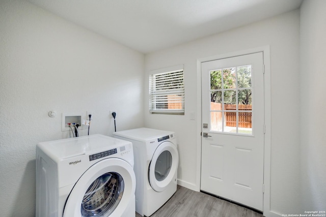 clothes washing area featuring washing machine and dryer and light hardwood / wood-style flooring