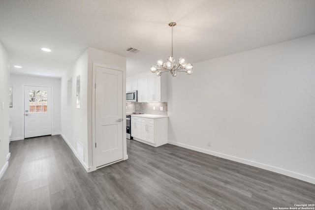 unfurnished dining area with dark hardwood / wood-style flooring and a chandelier