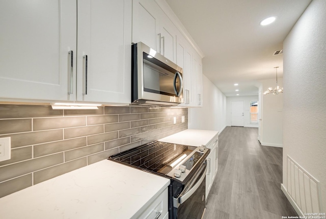 kitchen with white cabinetry, tasteful backsplash, and stainless steel appliances