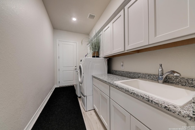 washroom featuring cabinets, separate washer and dryer, and sink