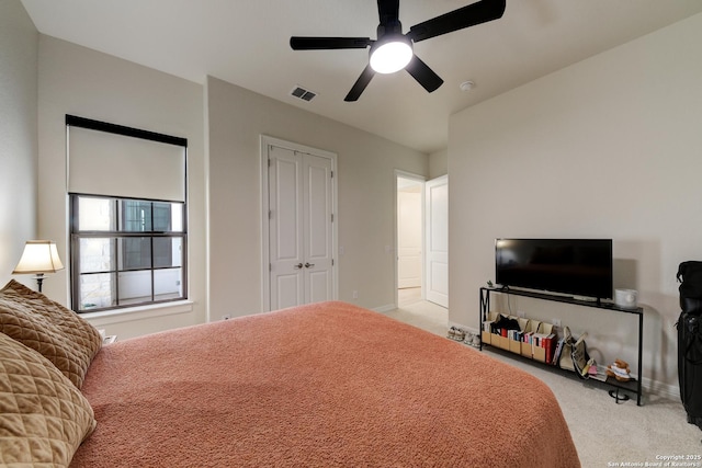 bedroom featuring light colored carpet, a closet, and ceiling fan