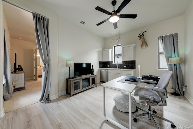 home office featuring sink, ceiling fan, and light wood-type flooring