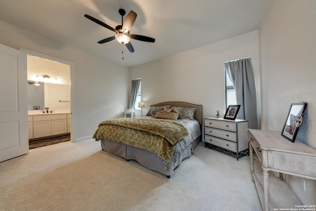 carpeted bedroom with ceiling fan, sink, and ensuite bath