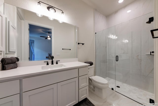 bathroom featuring vanity, toilet, ceiling fan, and a shower with shower door