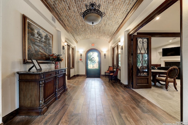 foyer with brick ceiling, lofted ceiling, and hardwood / wood-style floors