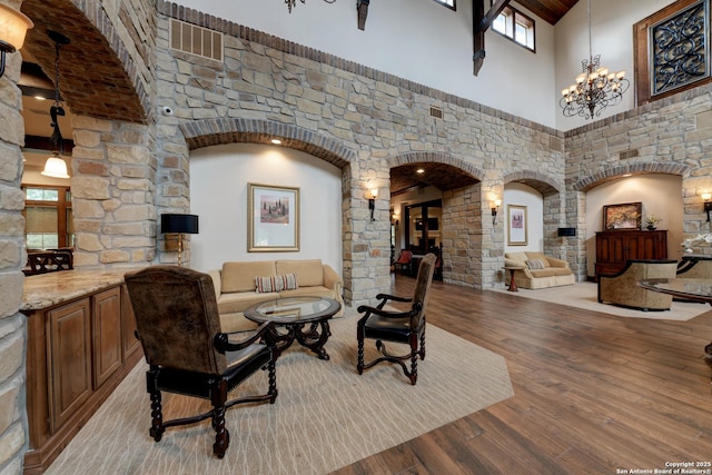 interior space with a high ceiling, a notable chandelier, and light hardwood / wood-style floors