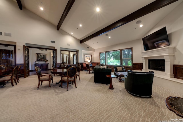 living room featuring high vaulted ceiling, light carpet, and beam ceiling