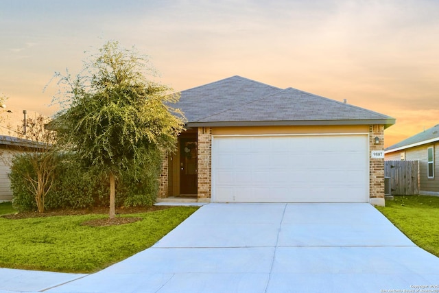 view of front of home with a garage and a lawn