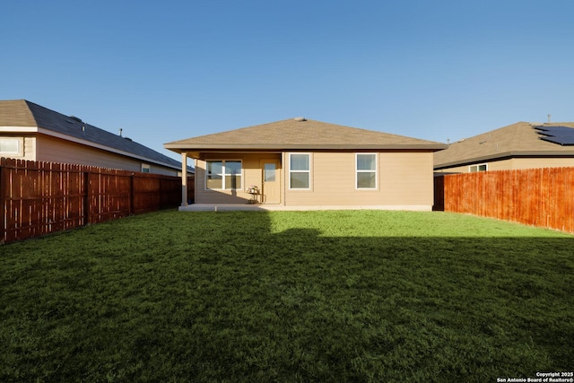 rear view of property featuring a patio and a lawn