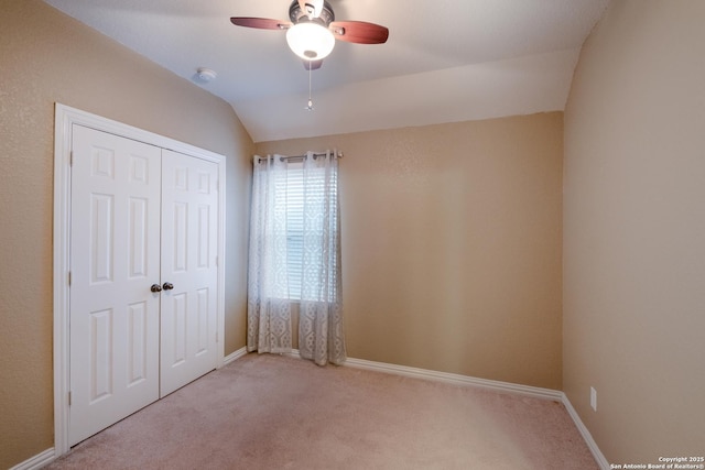 unfurnished bedroom with vaulted ceiling, light carpet, ceiling fan, and a closet