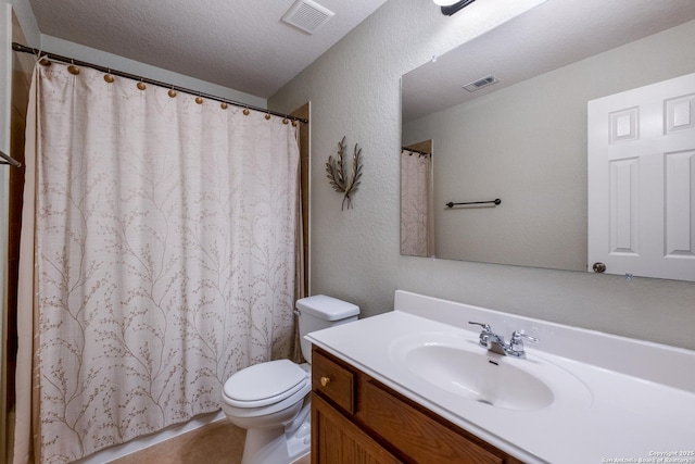 bathroom featuring vanity, toilet, and a textured ceiling