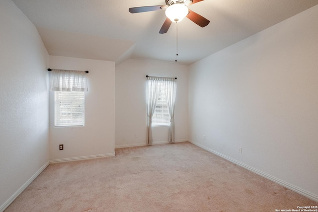 carpeted spare room featuring lofted ceiling and ceiling fan