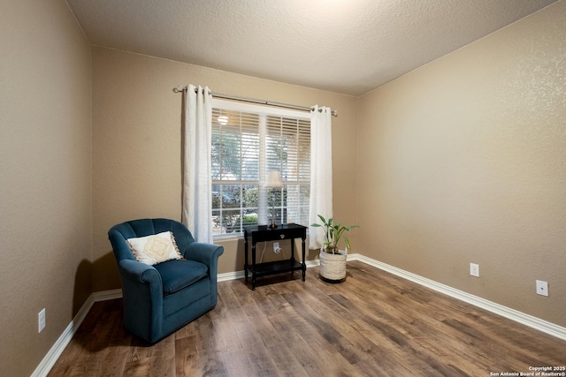 living area featuring dark hardwood / wood-style floors and a textured ceiling