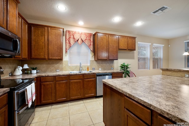 kitchen featuring tasteful backsplash, appliances with stainless steel finishes, sink, and light tile patterned floors