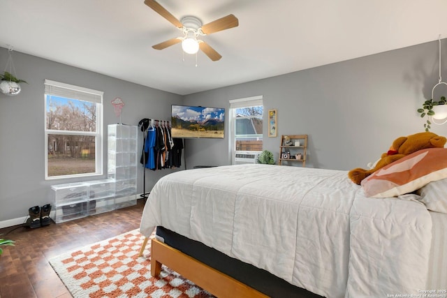 bedroom featuring cooling unit, ceiling fan, dark hardwood / wood-style floors, and multiple windows