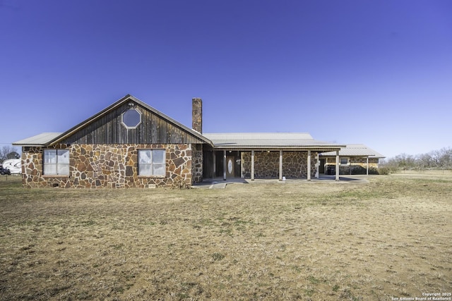 rear view of house featuring a yard