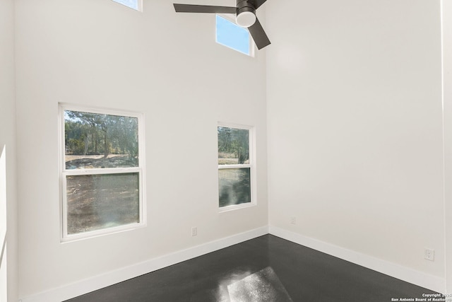 spare room with a towering ceiling, plenty of natural light, and ceiling fan