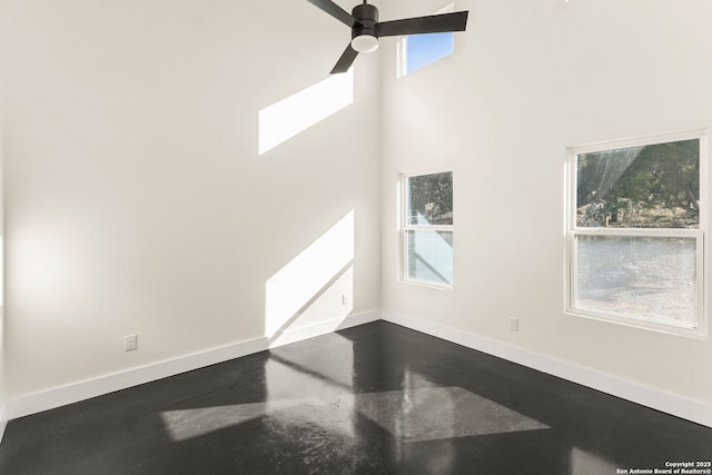 living room featuring a high ceiling, concrete floors, and ceiling fan