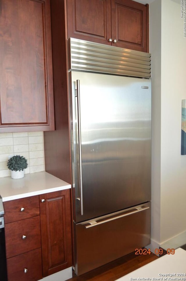 kitchen with stainless steel built in fridge and backsplash