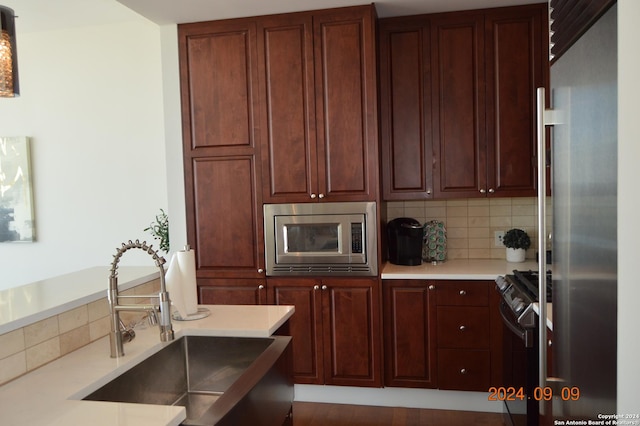 kitchen featuring stainless steel appliances, sink, and backsplash