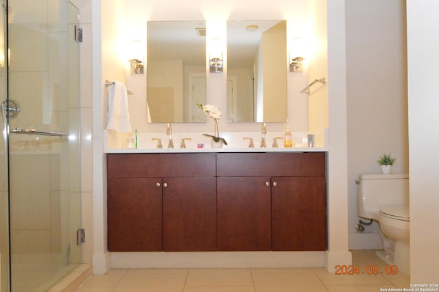 bathroom with tile patterned flooring, vanity, an enclosed shower, and toilet