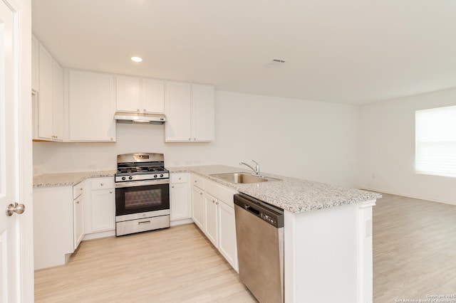 kitchen with appliances with stainless steel finishes, sink, white cabinets, and light hardwood / wood-style floors