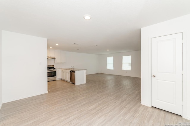 unfurnished living room featuring sink and light hardwood / wood-style floors