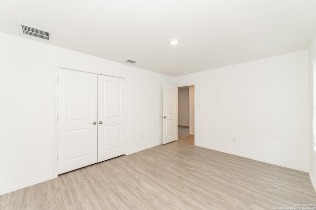 unfurnished bedroom featuring light hardwood / wood-style flooring and a closet