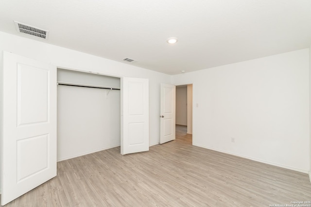 unfurnished bedroom with light hardwood / wood-style flooring and a closet