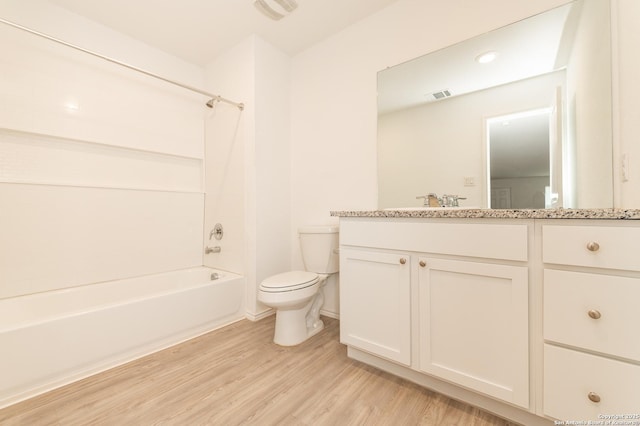 full bathroom featuring hardwood / wood-style flooring, bathing tub / shower combination, vanity, and toilet