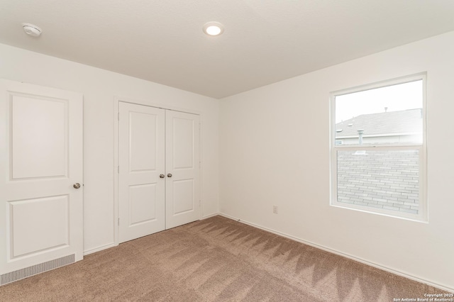 unfurnished bedroom with carpet floors and a closet