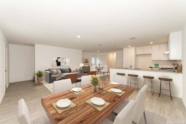 dining area with sink and light hardwood / wood-style floors