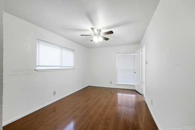 empty room featuring ceiling fan and dark hardwood / wood-style flooring