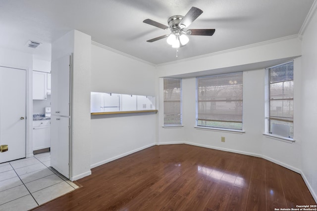 empty room featuring ceiling fan, ornamental molding, and light hardwood / wood-style flooring