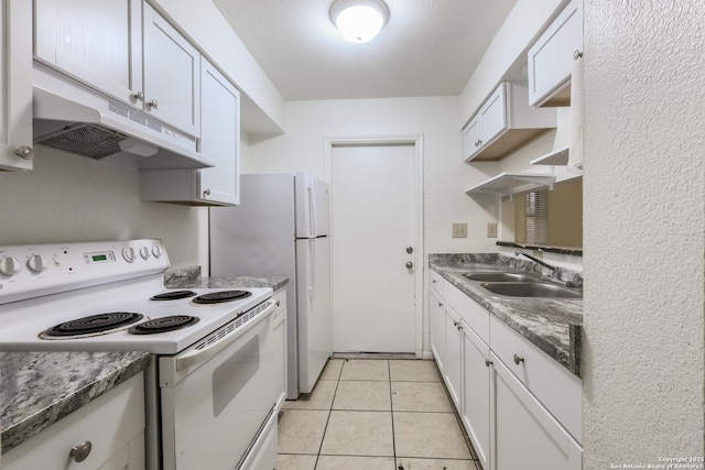 kitchen with light tile patterned floors, white appliances, sink, dark stone countertops, and white cabinets