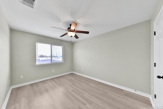 spare room with ceiling fan and light wood-type flooring