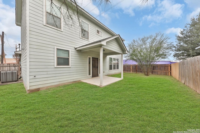 rear view of house featuring a yard, central AC unit, and a patio area