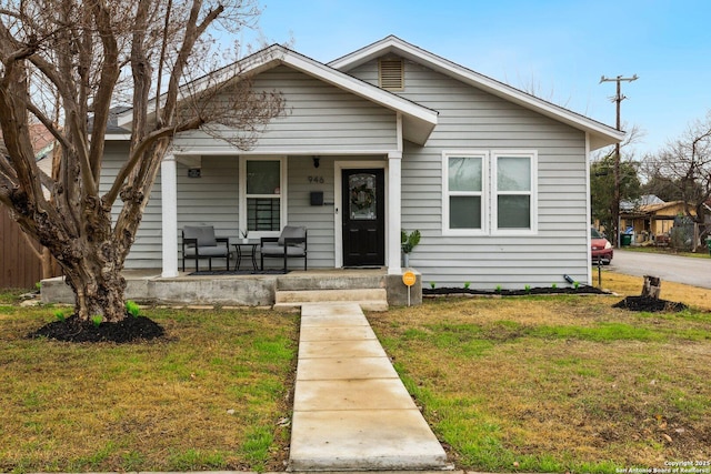 bungalow-style house featuring a front yard and covered porch