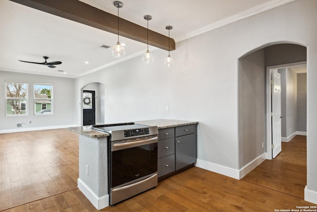 kitchen with light stone counters, crown molding, dark hardwood / wood-style flooring, pendant lighting, and stainless steel electric stove