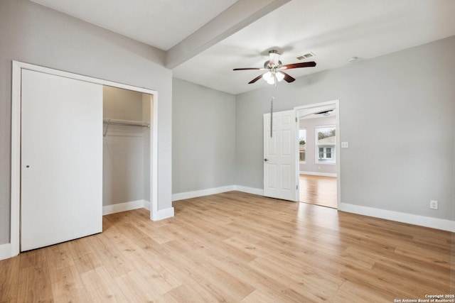 unfurnished bedroom with beamed ceiling, ceiling fan, light hardwood / wood-style floors, and a closet