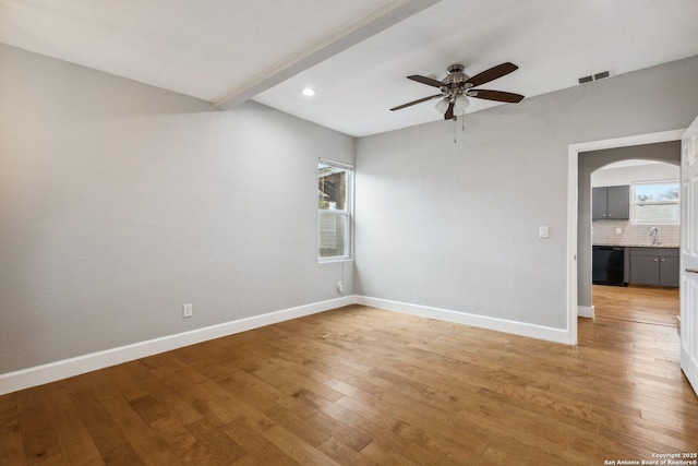 empty room with sink, light hardwood / wood-style floors, and ceiling fan